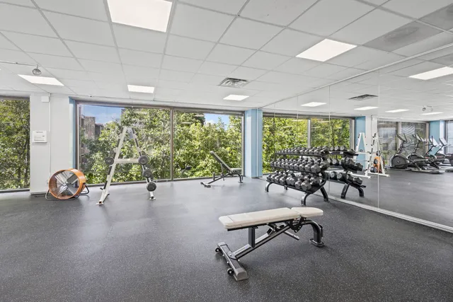 a view of a room with gym equipment and large windows