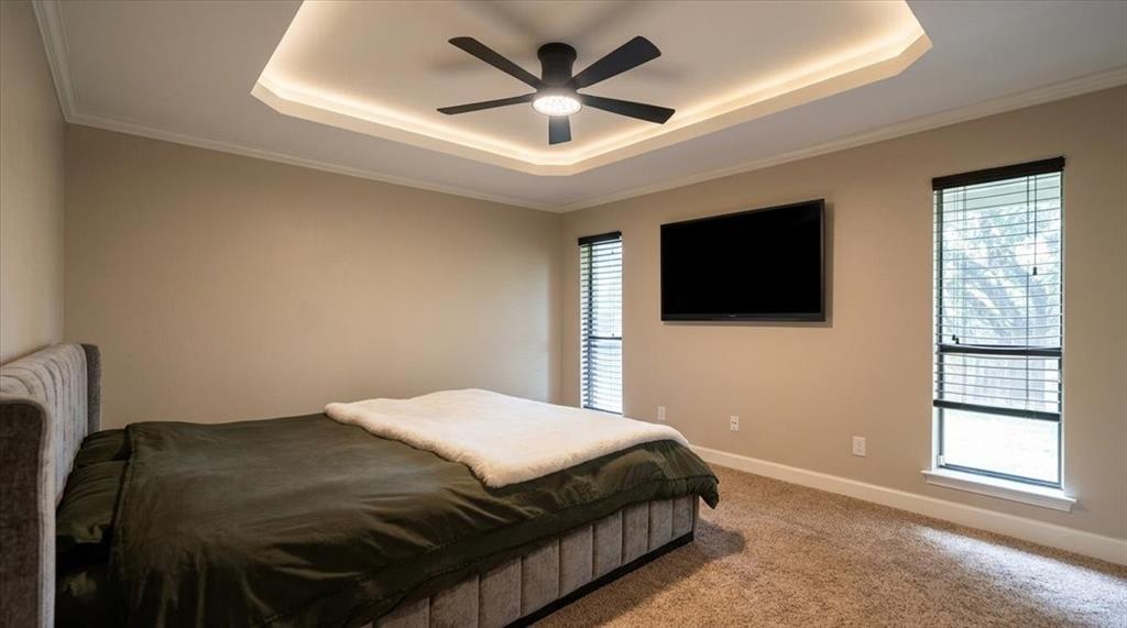504 Bluebird Lane Red Oak, TX 75154 - Photo 13 of 28 a bedroom with a bed and a flat screen tv