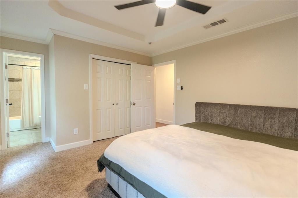 504 Bluebird Lane Red Oak, TX 75154 - Photo 15 of 28 a bedroom with a large bed and a chandelier fan