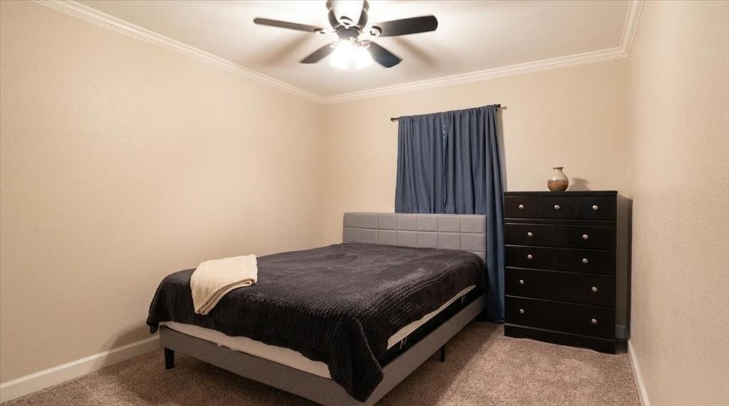 504 Bluebird Lane Red Oak, TX 75154 - Photo 17 of 28 a bedroom with a bed and a chandelier
