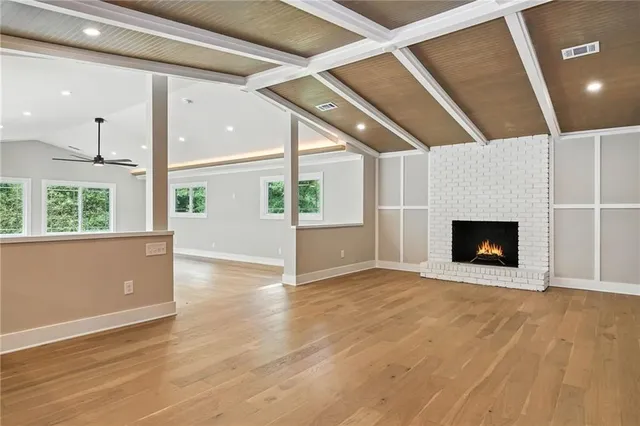an empty room with wooden floor and a fireplace