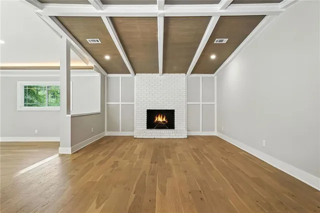 an empty room with wooden floor and fireplace
