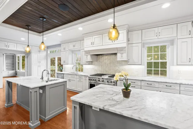 a kitchen with kitchen island granite countertop a sink a counter space appliances and cabinets