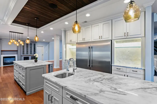 a kitchen with a sink stainless steel appliances and white cabinets