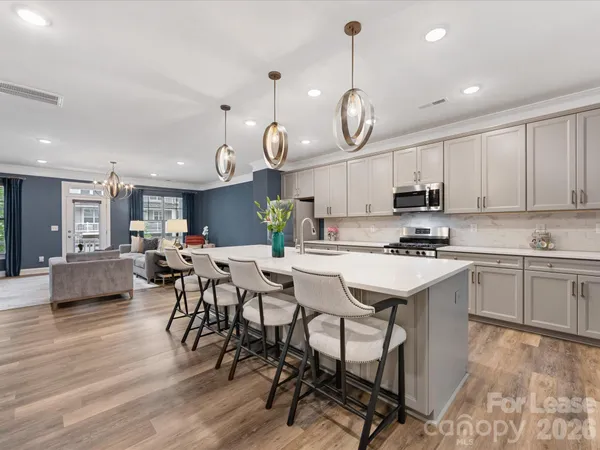 a kitchen with a dining table cabinets and stainless steel appliances
