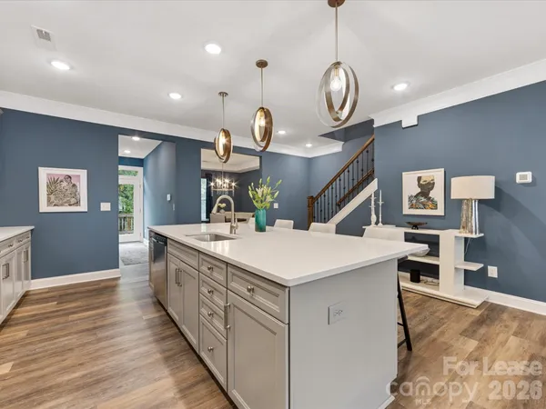 a large kitchen with stainless steel appliances a large center island attached withe living room