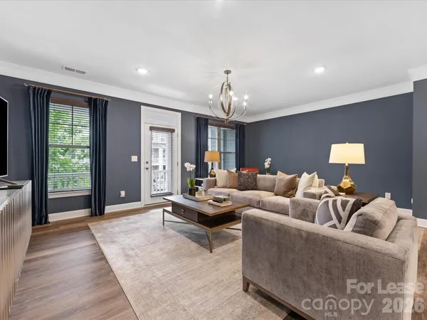 a living room with furniture and wooden floor