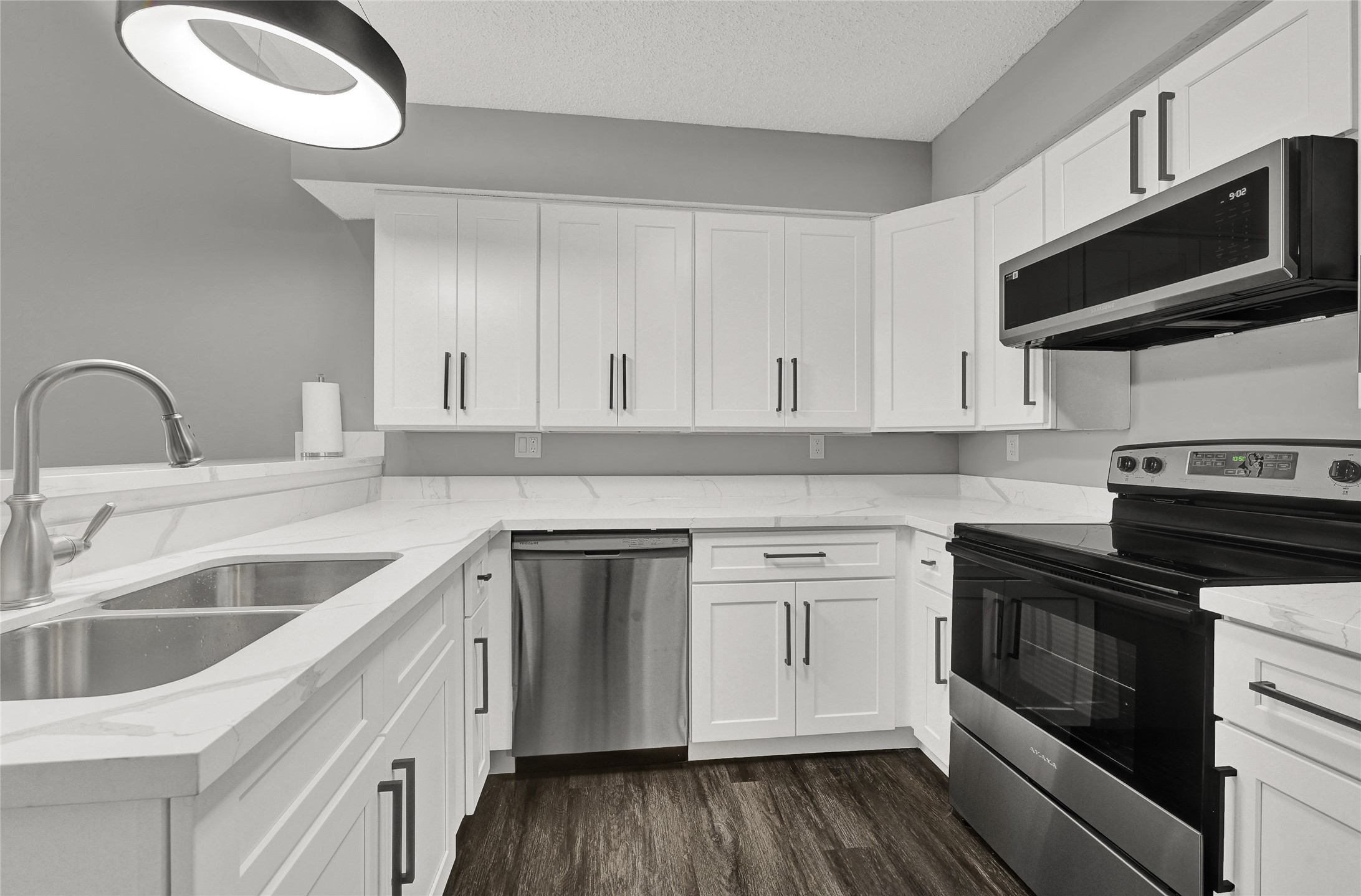 a kitchen with stainless steel appliances granite countertop a sink and dishwasher a stove top oven with wooden floor