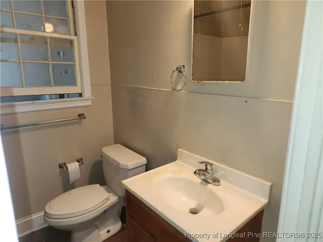 a bathroom with a sink toilet and a mirror