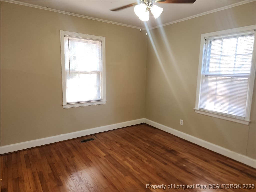 231 Pinecrest Drive Fayetteville, NC 28305 - Photo 5 of 8 an empty room with wooden floor and windows