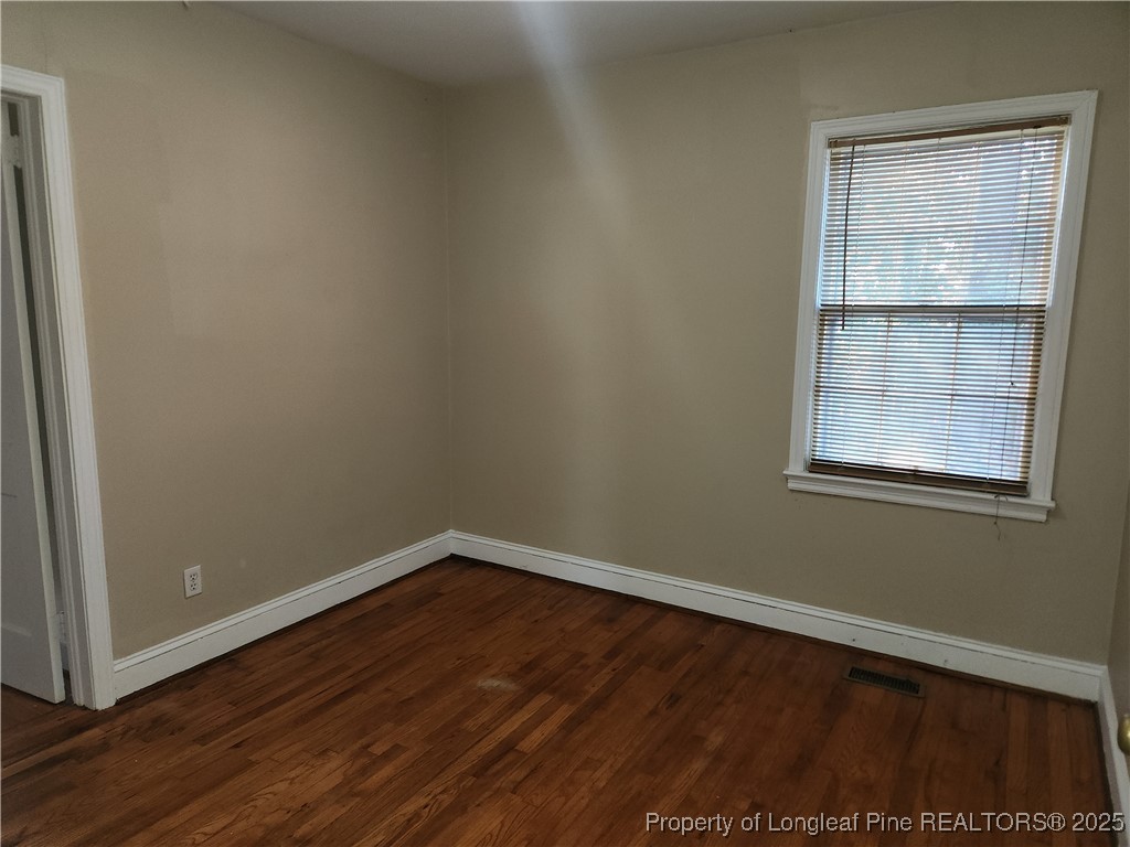 231 Pinecrest Drive Fayetteville, NC 28305 - Photo 6 of 8 an empty room with wooden floor and windows