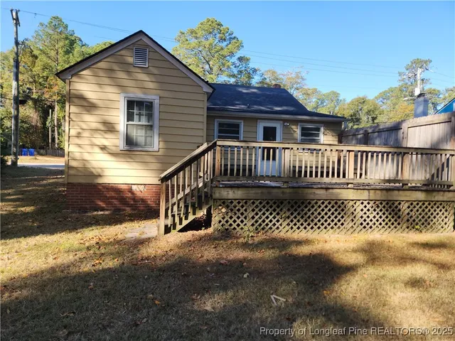 a view of a house with a small yard and wooden fence