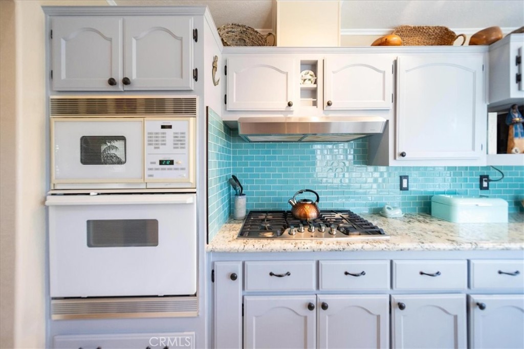 35493 Sand Rock Road Thousand Palms, CA 92276 - Photo 13 of 71 a kitchen with granite countertop white cabinets and white appliances