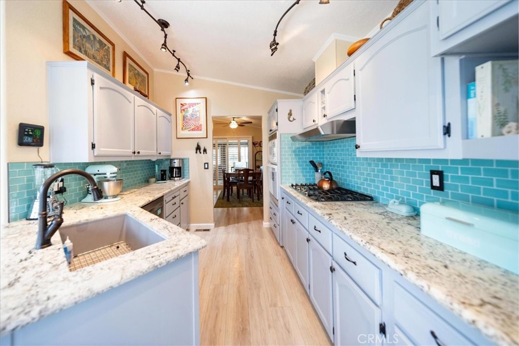 35493 Sand Rock Road Thousand Palms, CA 92276 - Photo 14 of 71 a large kitchen with granite countertop a sink a stove and a wooden cabinets