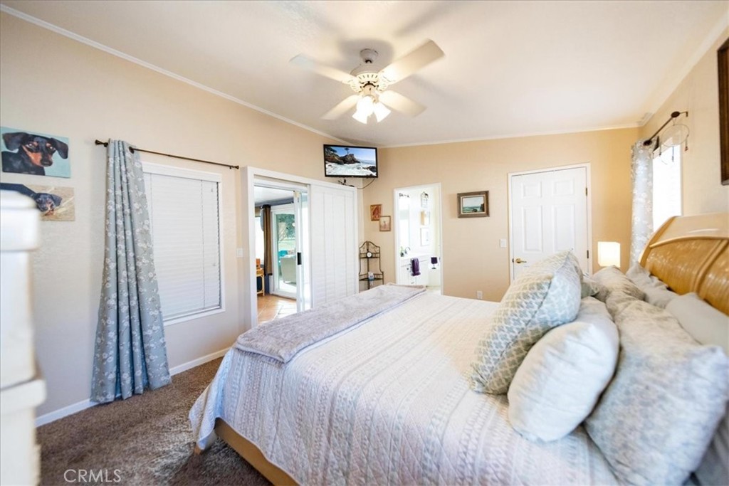 35493 Sand Rock Road Thousand Palms, CA 92276 - Photo 24 of 71 a bedroom with a large bed and a chandelier