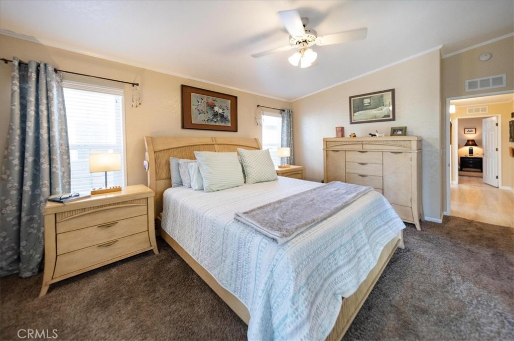 35493 Sand Rock Road Thousand Palms, CA 92276 - Photo 25 of 71 a spacious bedroom with a large bed and a chandelier