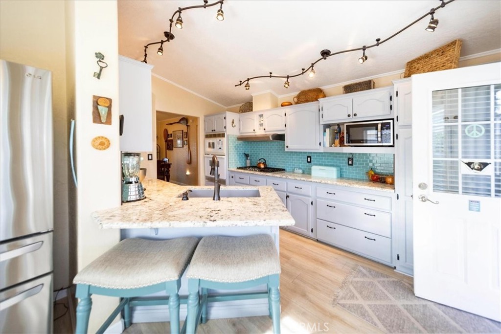 35493 Sand Rock Road Thousand Palms, CA 92276 - Photo 3 of 71 a kitchen with stainless steel appliances kitchen island granite countertop a refrigerator and microwave