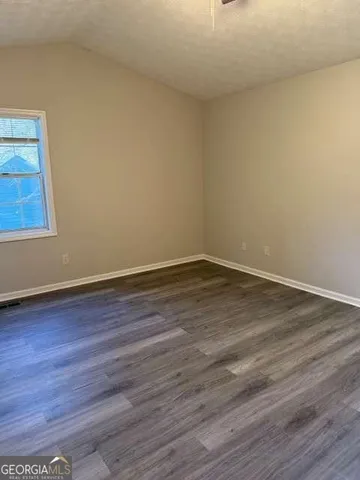 a view of a room that has wooden floor and large window