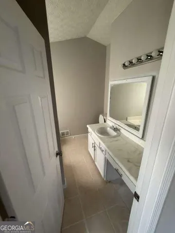 a bathroom with a sink and mirror with toilet