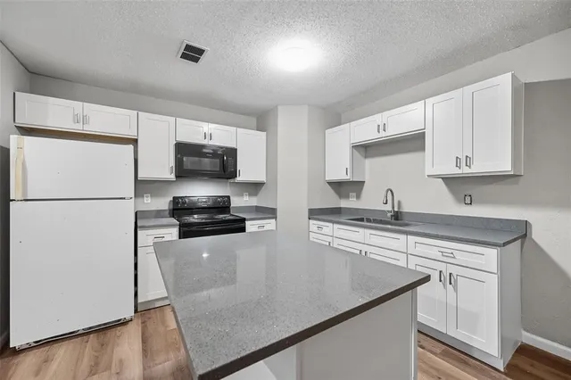 a kitchen with stainless steel appliances a refrigerator and a stove top oven