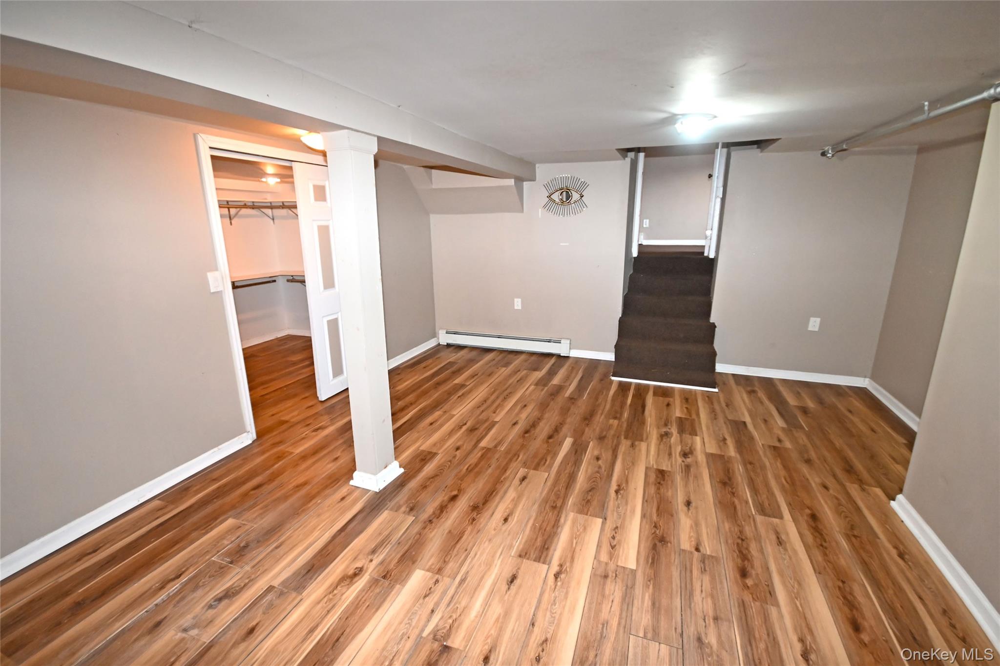 89 Osborne Road West Hempstead, NY 11552 - Photo 46 of 50 Finished below grade area featuring stairs, light wood-style floors, and a baseboard heating unit