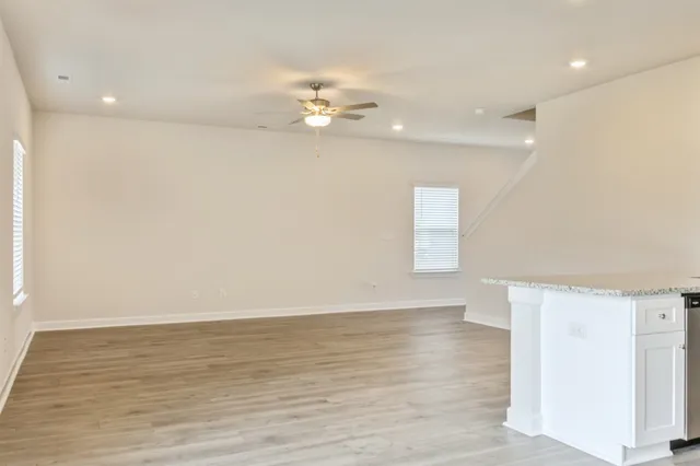 an empty room with wooden floor and windows