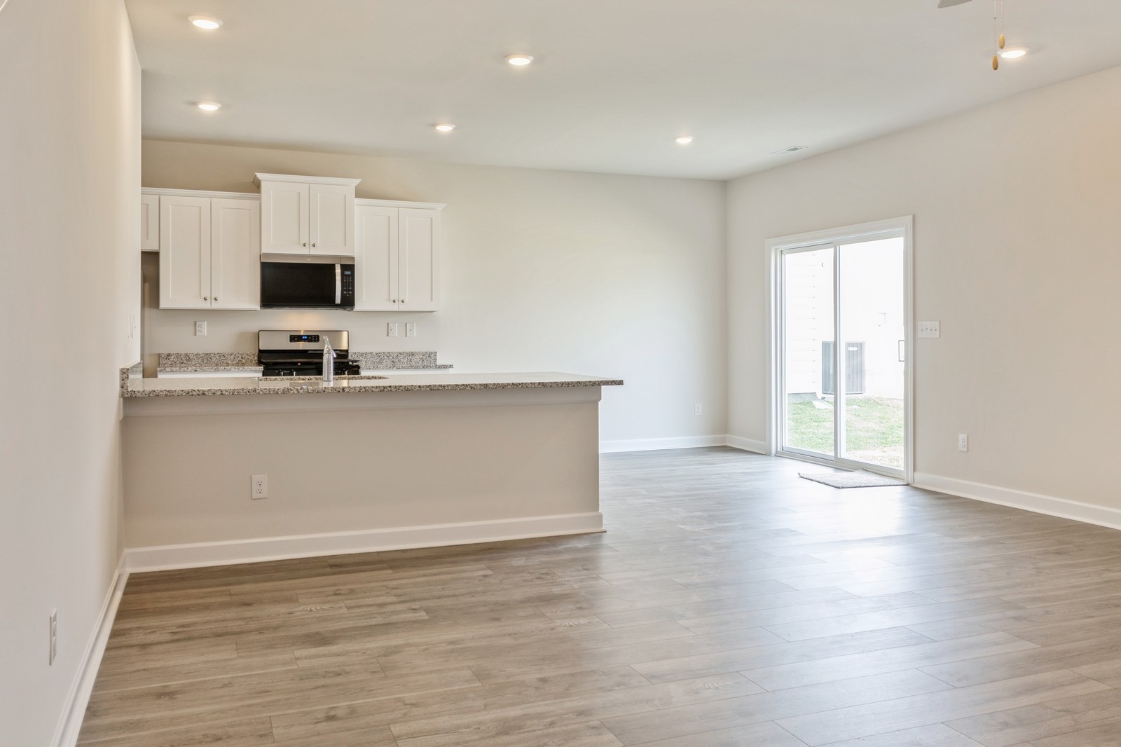 2334 Nabali Way Murfreesboro, TN 37127 - Photo 22 of 25 a view of a kitchen with kitchen island a sink wooden floor and black appliances