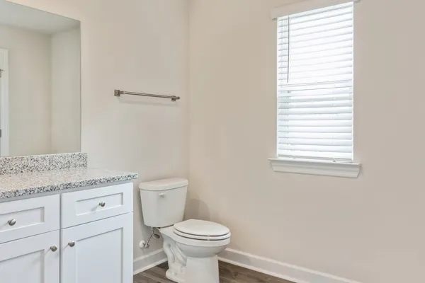a bathroom with a granite countertop toilet and a sink