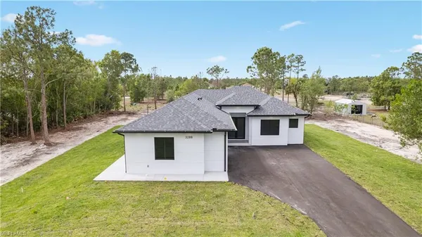 a house with green field in front of it