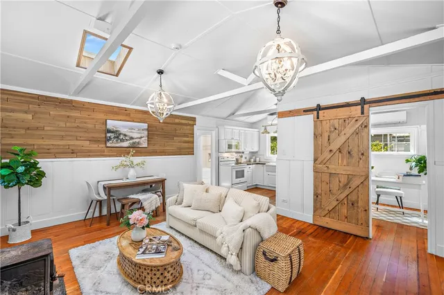 a living room with furniture a chandelier and a potted plant