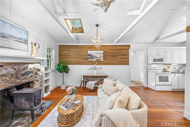 a kitchen with stainless steel appliances a white cabinets and wooden floors