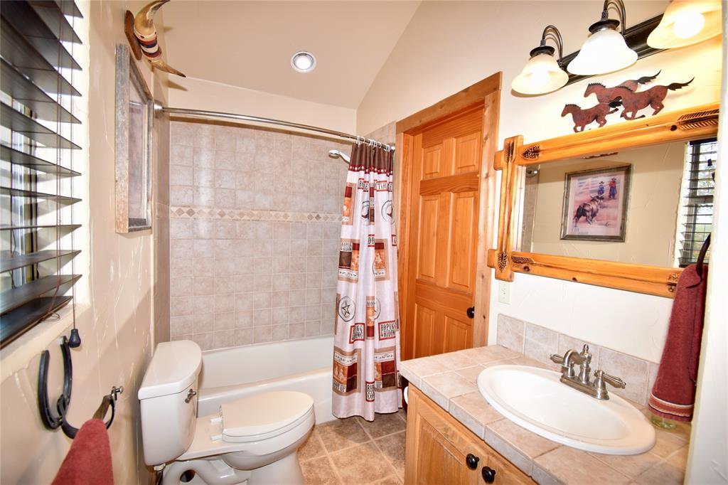 19319 Ranch Road 1871 Mason, TX 76856 - Photo 12 of 40 a bathroom with a sink a toilet a mirror a bathtub and shower