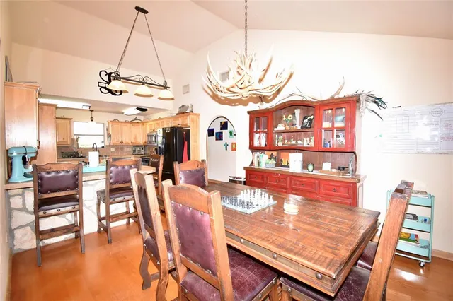 a view of a dining room with furniture a chandelier and wooden floor