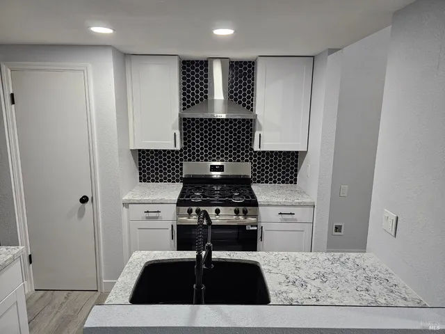 a kitchen with a stove and white cabinets