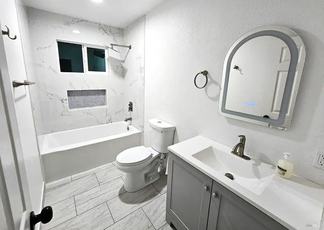 a bathroom with a toilet sink and mirror