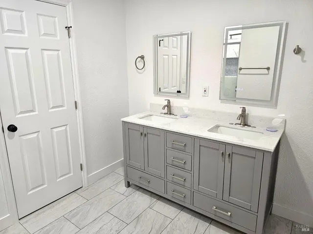 a spacious bathroom with a double vanity sink and a mirror