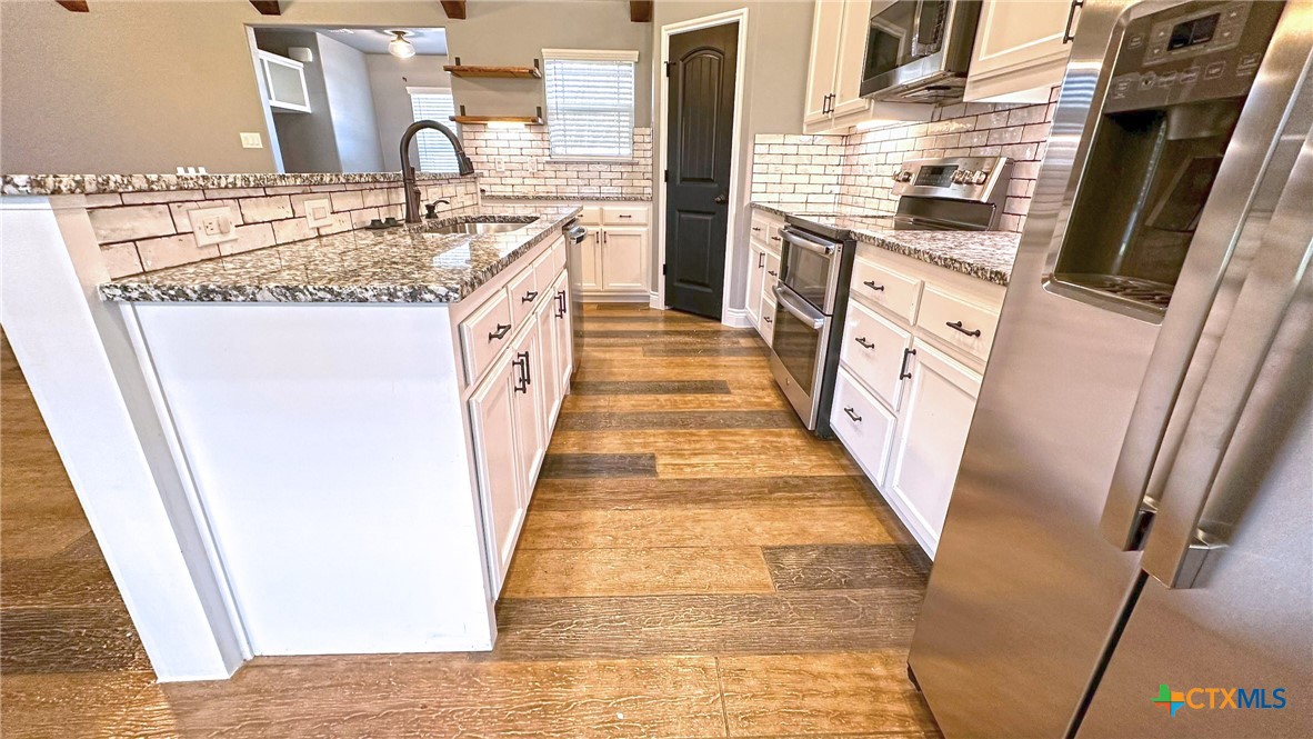1142 Lutheran Church Road Copperas Cove, TX 76522 - Photo 5 of 48 a kitchen with granite countertop sink stove and cabinets