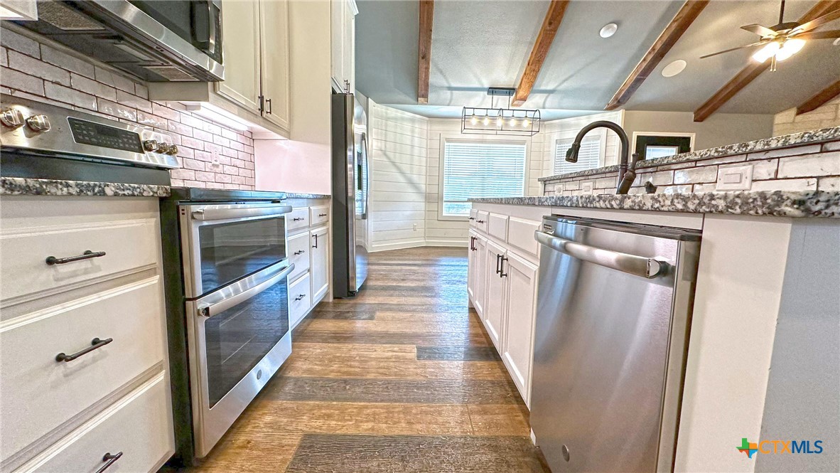 1142 Lutheran Church Road Copperas Cove, TX 76522 - Photo 6 of 48 a kitchen with stainless steel appliances granite countertop a sink and dishwasher a stove top oven with a dishwasher