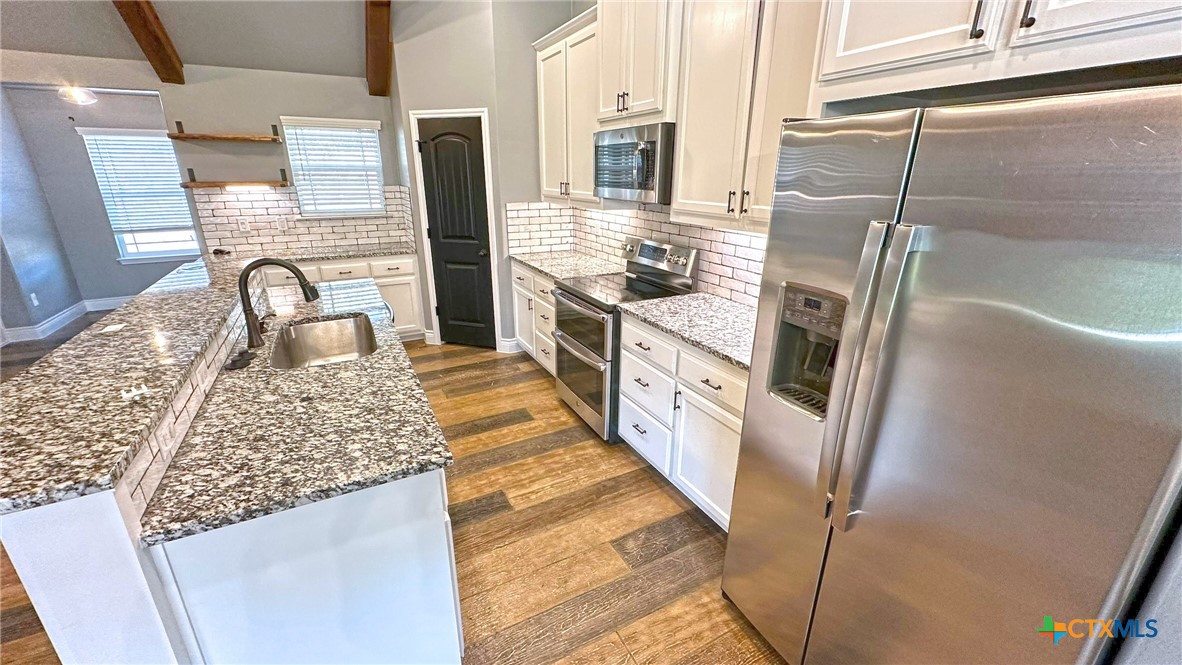 1142 Lutheran Church Road Copperas Cove, TX 76522 - Photo 7 of 48 a kitchen with stainless steel appliances granite countertop a sink stove and refrigerator