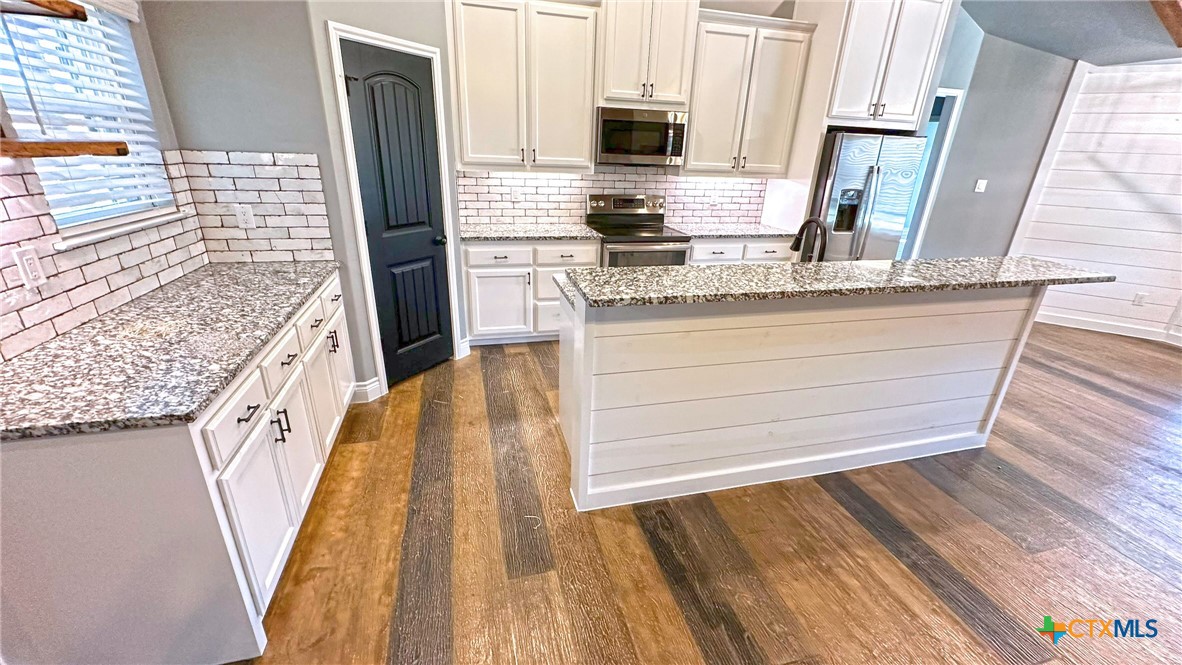 1142 Lutheran Church Road Copperas Cove, TX 76522 - Photo 8 of 48 a kitchen with stainless steel appliances granite countertop a stove and a refrigerator