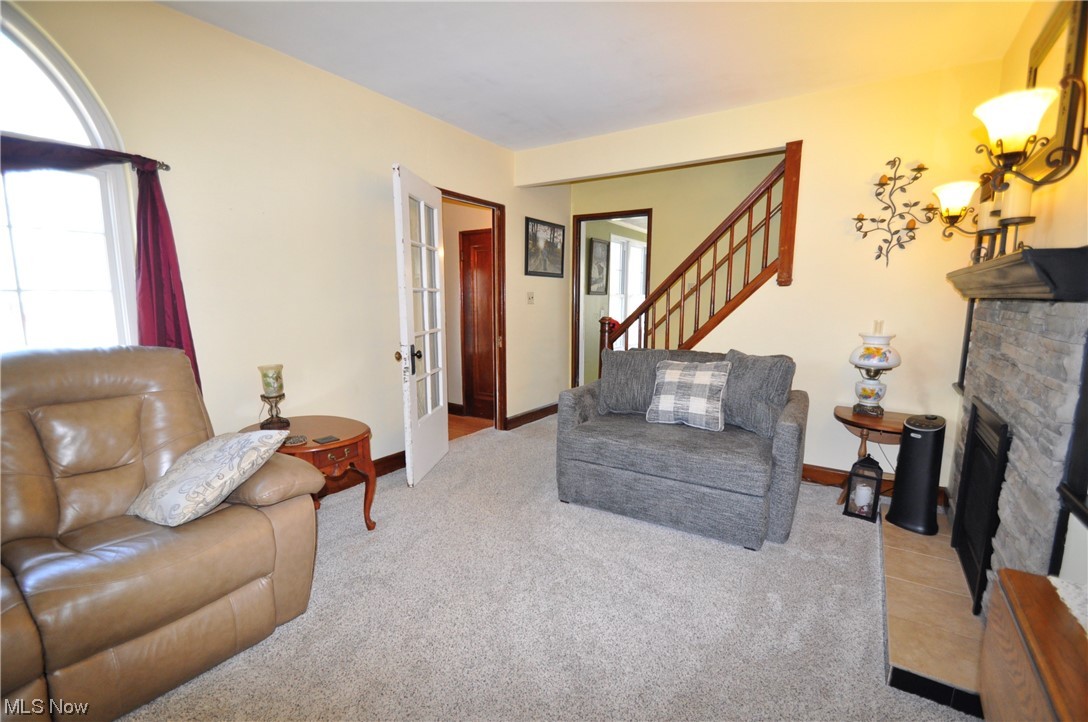 1899 West Pleasant Valley Road Parma, OH 44134 - Photo 4 of 47 Living room featuring light carpet, a stone fireplace, and french doors