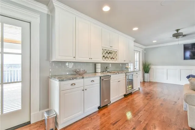 a kitchen with white cabinets and sink