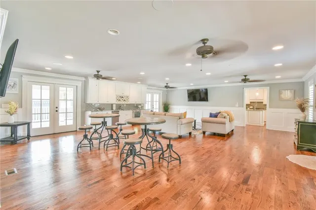 a living room with furniture and kitchen view with wooden floor