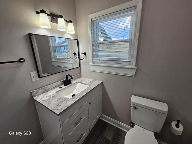 a bathroom with a toilet sink and mirror