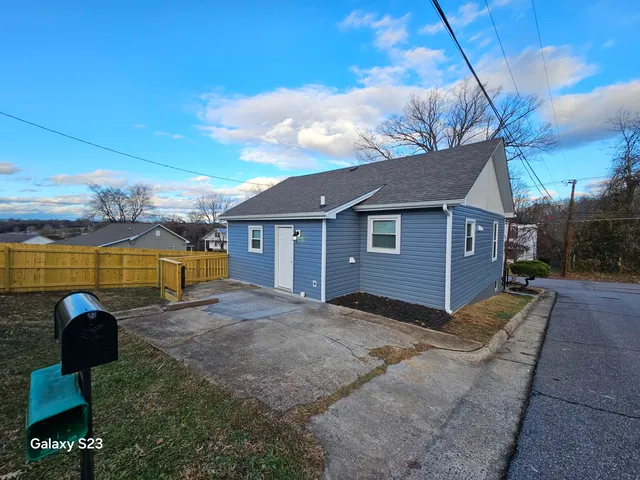 a view of a house with backyard and a patio