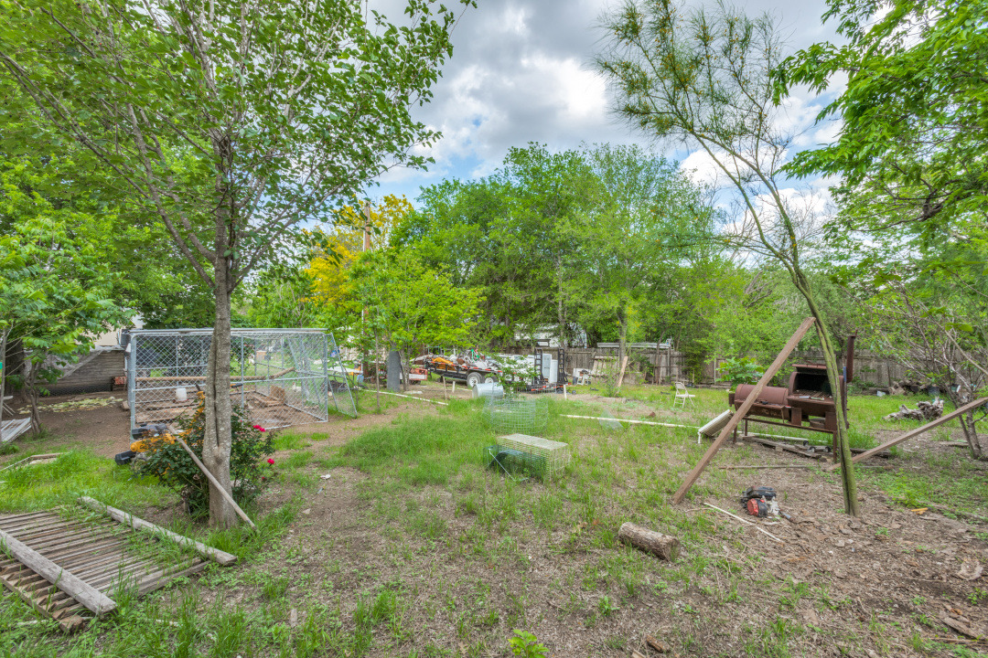 404 Quail Run Buda, TX 78610 - Photo 8 of 13 The property features an outdoor area with natural ground cover, surrounded by mature trees