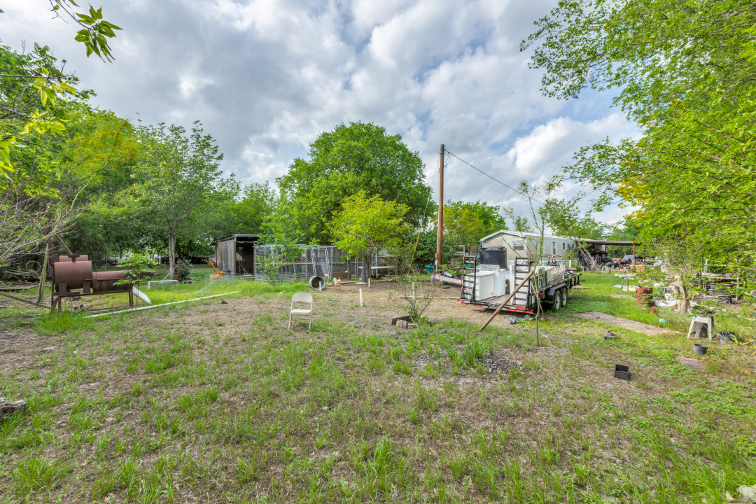 404 Quail Run Buda, TX 78610 - Photo 10 of 13 The property includes an expansive yard with an abundance of mature trees and established greenery