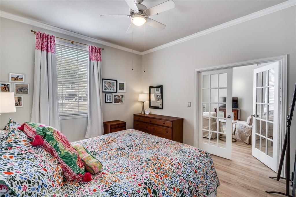 2305 Worthington Street, Unit 104 Dallas, TX 75204 - Photo 13 of 25 a bedroom with a bed dresser and wooden floor