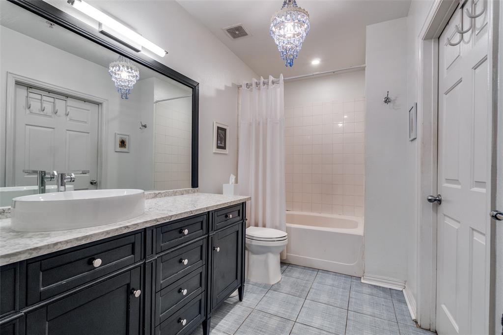 2305 Worthington Street, Unit 104 Dallas, TX 75204 - Photo 15 of 25 a spacious bathroom with a granite countertop sink a toilet a mirror and shower