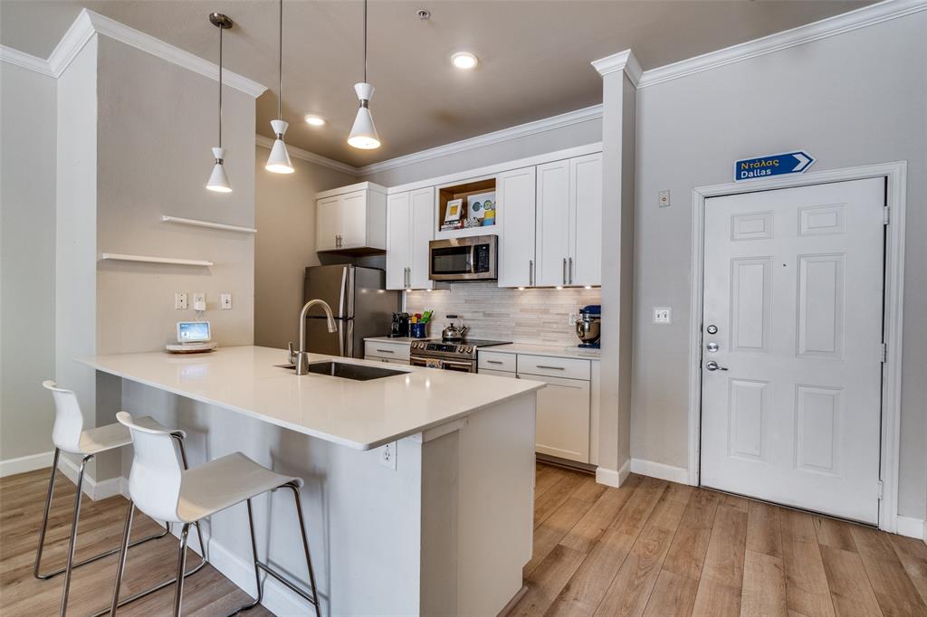 2305 Worthington Street, Unit 104 Dallas, TX 75204 - Photo 4 of 25 a kitchen with a sink a counter top space stainless steel appliances and cabinets